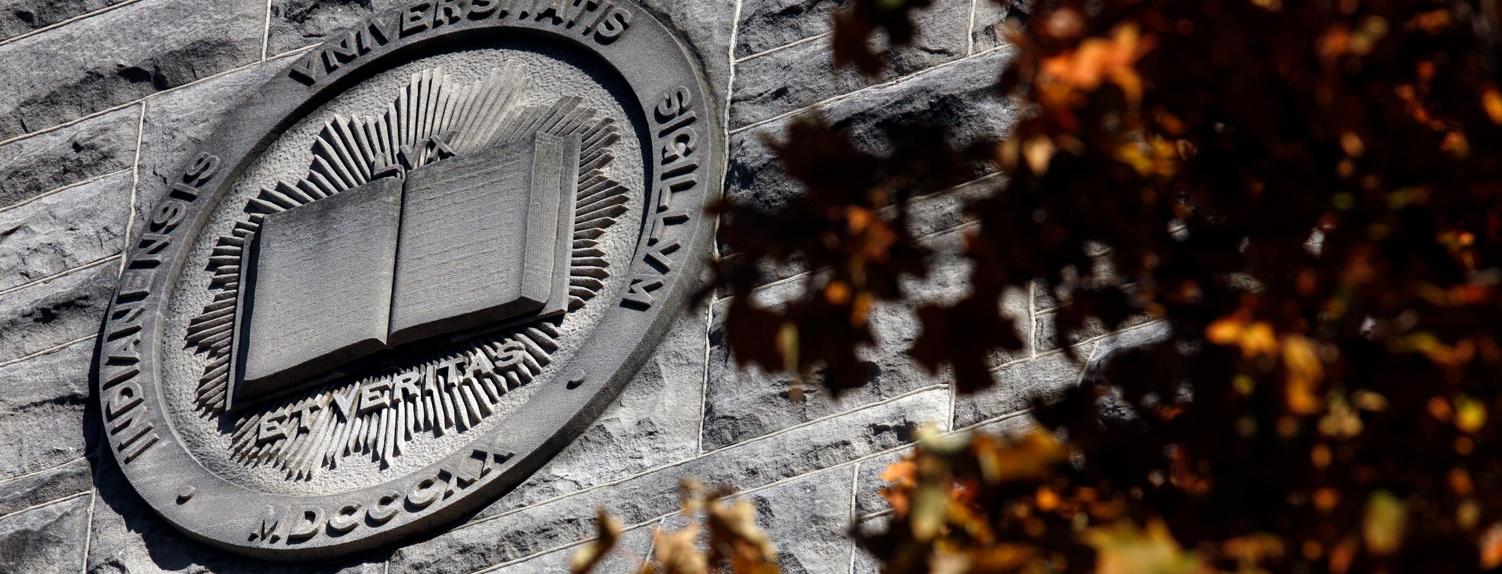 Indiana University latin seal carved into the side of a building
